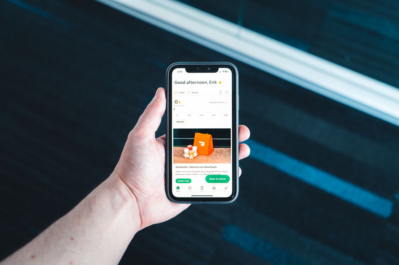 Käsi pitelee puhelinta, jonka näytöllä on auki keskustelusovellus